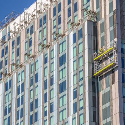 Construction workers on a building implementing cladding
